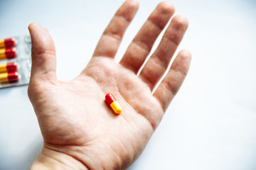 Pills in a hand on a white background.