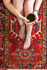 Füße und Beine einer Frau, entspannt auf Orient-Teppich
