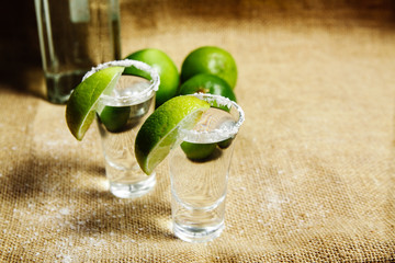 Tequila in shots with green lime.