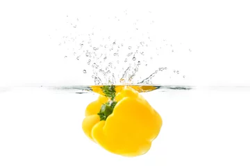 Poster Yellow bellpepper dropped into the water with water splash on a white background © makistock