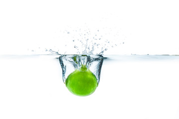 Fresh lime dropped into the water with water splash on a white background