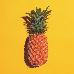 Summer fruit. Pineapple on bright yellow background.