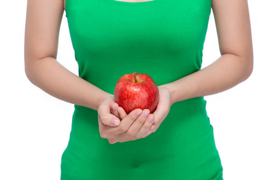Fruit. Beautiful female hand holding and showing a red apple on white background