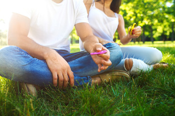 Young girl and boy playing with a fidget spinners in the park. stress relieving toy. Sunny summer day. They laugh and smile. Great mood.
 - obrazy, fototapety, plakaty