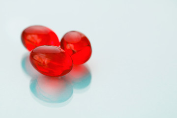 Close-up of red painkiller pills on a blue background.