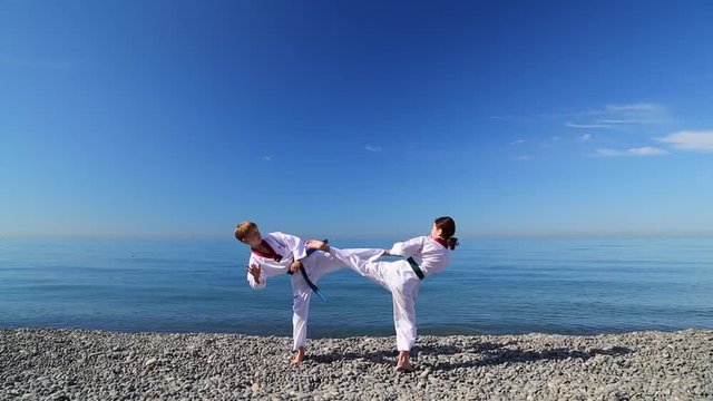 Тренировка двух детей на пляже: тхэквондо, спорт, спарринг