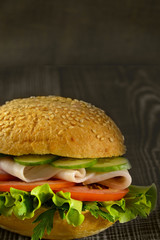 fresh sandwich with ham on wooden background
