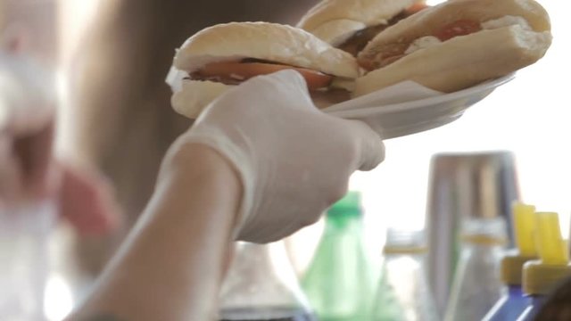 Cuoco sta servendo dei panini alla piastra in un lido per vacanze estive