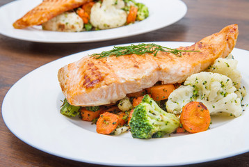 salmon fillet on a bed of broccoli, cauliflower and carrots