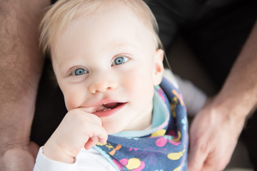 Close up of beautiful and happy baby girl with blue eyes. Top view.
