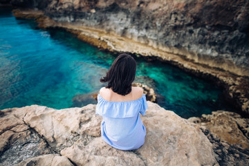Young woman enjoying beautiful sea view on Greco cape in Cyprus