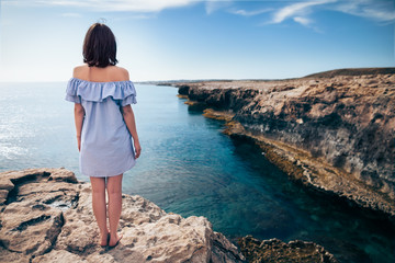 Young woman enjoying beautiful sea view on Greco cape in Cyprus