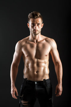 Portrait of a sexy muscular shirtless man on dark background