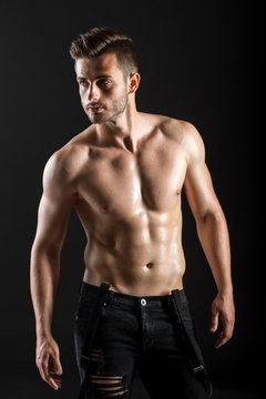 Portrait of a sexy muscular shirtless man on dark background