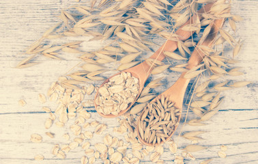 Raw oat flakes on a wooden table - closeup.