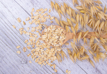 Raw oat flakes on a wooden table - closeup.