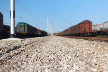 Close Up Narrow shot of a railway stones and rocks close to freight train at the Italian train...