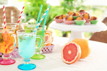 Glasses with different kinds of lemonade on table, outdoor