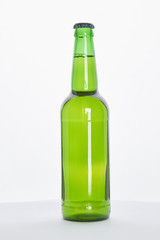 Green bottle with fresh beer. Single bottle of alcoholic beverage on white background.