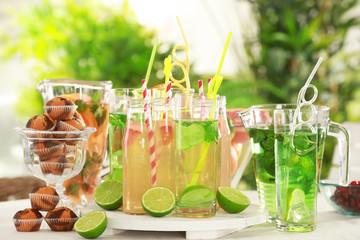 Glassware with different kinds of lemonade on table outdoor