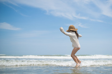 Naklejka premium Happy little girl playing on the beach