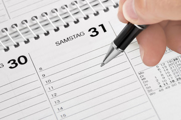 Hand, Kugelschreiber und Kalender