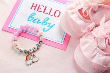 Bracelet with baby name OLIVIA, greeting card and booties on light cloth