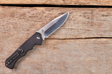 Sharp knife isolated on wooden background. Steel tool for threaten. Cold weapon on old wooden floor.