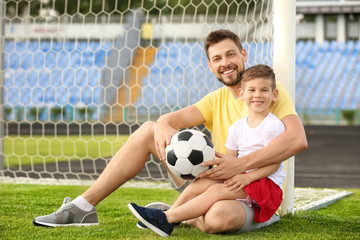 Dad and son with soccer ball in stadium