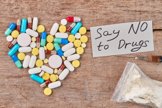 Say NO to Drugs. Heart from colorful pills, message, drugs, wooden background.