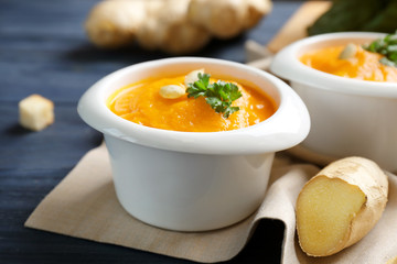Delicious carrot soup on wooden table