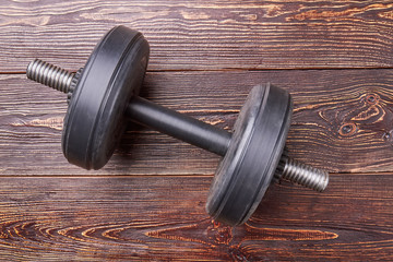 Dumbbell isolated on wooden background. Concept of gym and sport activity.