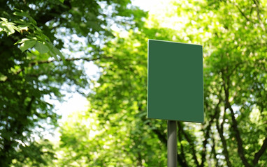 Blank board in green park on summer day