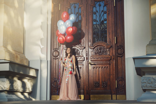 Woman in beautiful dress with a lot of colorful balloons