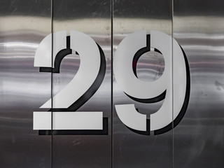 The number twenty-nine painted on a stainless steel door