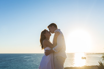 Couple embracing and kissing each other on the beach against ocean