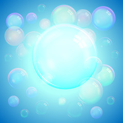 Colorful cool background of realistic transparent colorful soap bubbles with a rainbow reflection on a luminous blue background