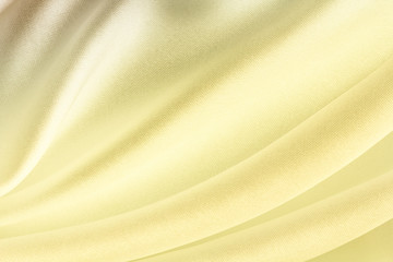 Fototapeta na wymiar bright golden satin fabric with large folds, soft abstract background
