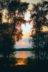 Naklejka premium Sunset on the river - a beautiful evening summer landscape. Russia. Vertical photography.