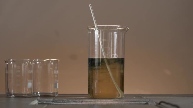 Chemical liquid in the flask changes color to transparent. From black to transparent. Chemical reaction