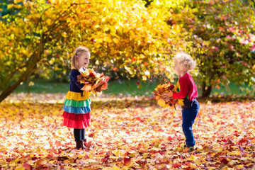 Kids play in autumn park. Children in fall.