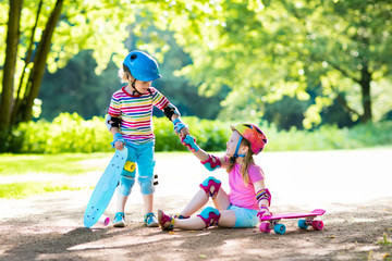 Children riding skateboard in summer park © famveldman