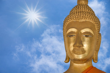 Obraz premium close up face of buddha with blue sky background