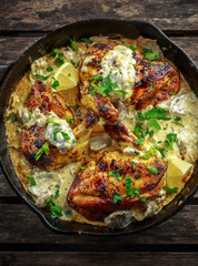 Creamy chicken fellets supremes in mushroom sauce with parsley In rustic cast iron skillet.