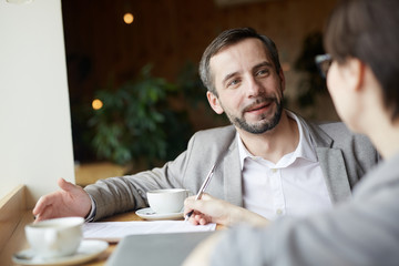 Employer having talk with applicant in cafe