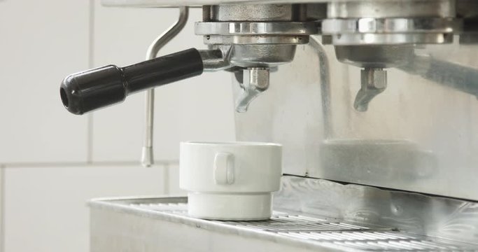 Barista makes espresso in a professonal coffee machine