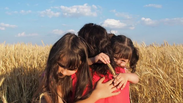 The children are hugging my mother. Family in a field of wheat.