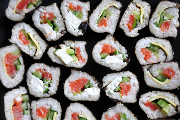 Homemade rolls made of rice, salmon, cheese and cucumber closeup. Sushi  texture.