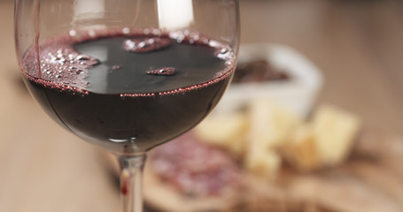 red wine pour in front of italian antipasti appetizers