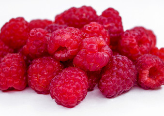 Heap of ripe raspberries on white